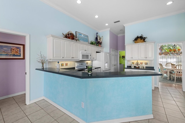 kitchen with dark countertops, white appliances, a peninsula, and light tile patterned floors