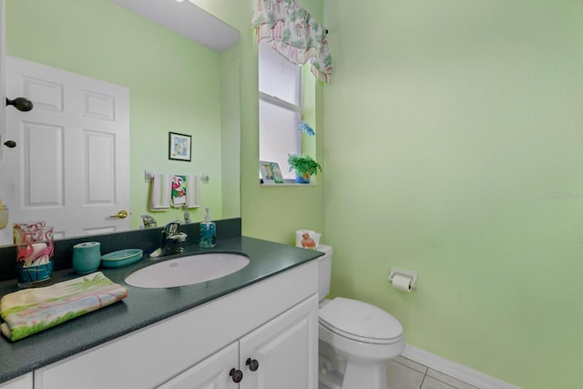 bathroom with baseboards, vanity, toilet, and tile patterned floors