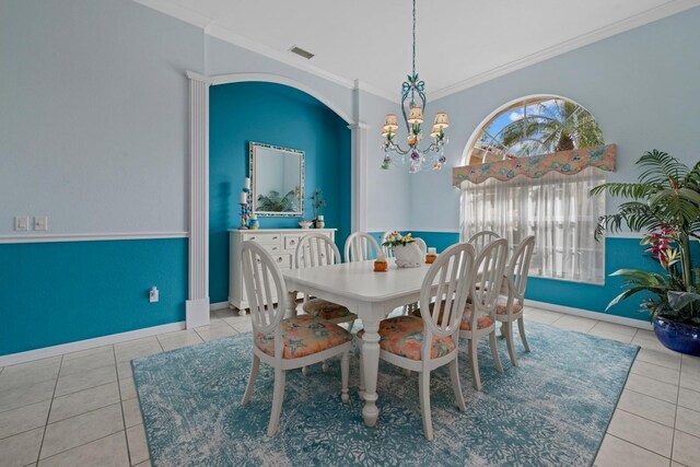 tiled dining room featuring arched walkways, a notable chandelier, visible vents, baseboards, and ornamental molding