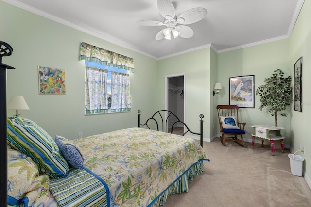 bedroom featuring carpet floors, baseboards, a walk in closet, and crown molding