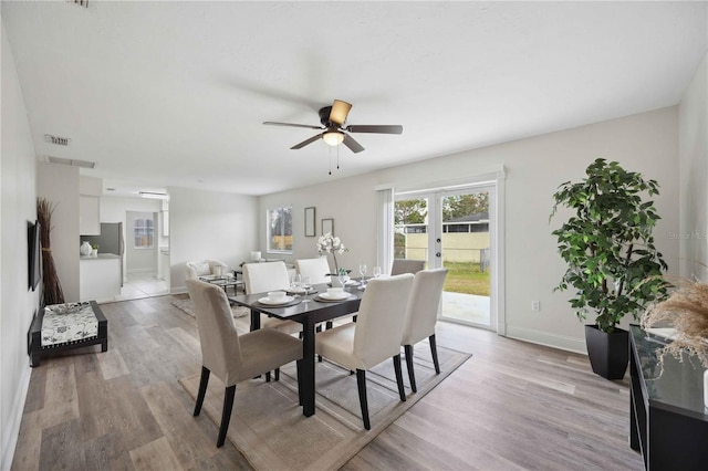 dining space with ceiling fan, french doors, and light wood-type flooring