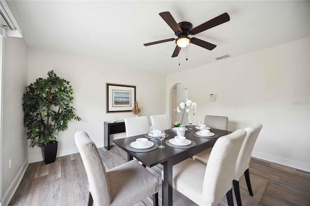 dining area with ceiling fan and dark hardwood / wood-style flooring