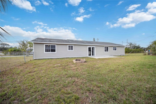 rear view of house with a yard, an outdoor fire pit, and a patio