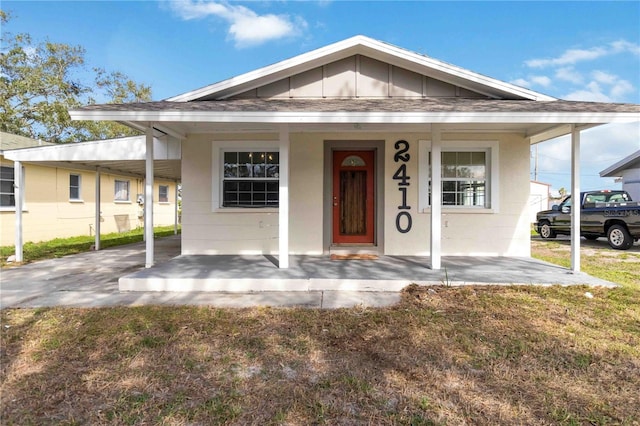 bungalow featuring a porch and a carport