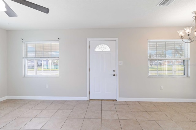 tiled entryway with ceiling fan with notable chandelier