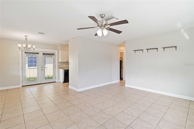 tiled spare room with french doors and ceiling fan with notable chandelier