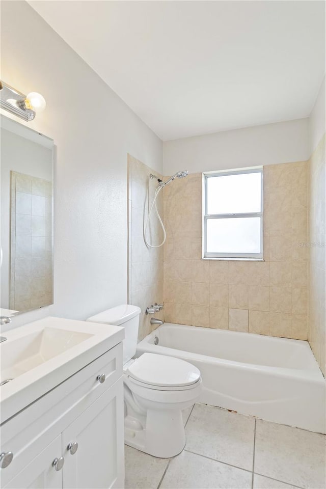 full bathroom with tile patterned flooring, vanity, tiled shower / bath combo, and toilet