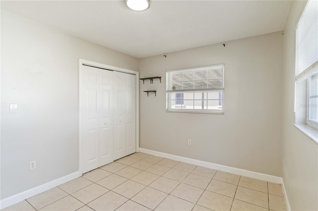 unfurnished bedroom featuring a closet and light tile patterned floors