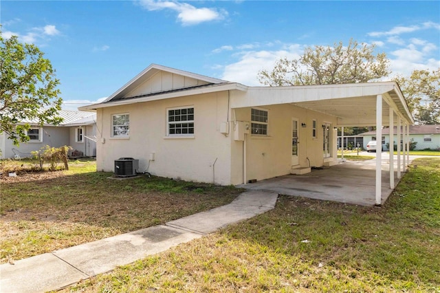 exterior space with central AC, a carport, and a lawn