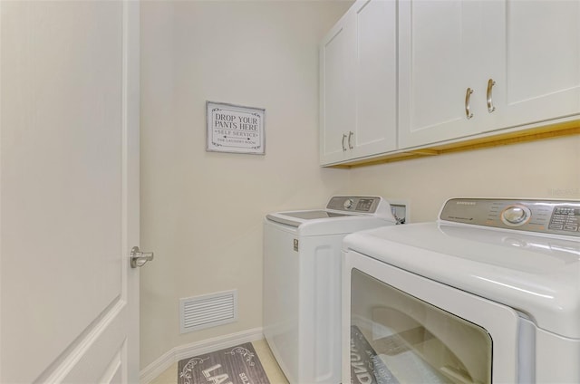 laundry area with cabinets and washing machine and dryer