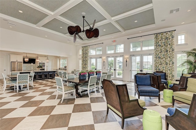 interior space with coffered ceiling, french doors, ceiling fan, a towering ceiling, and beamed ceiling