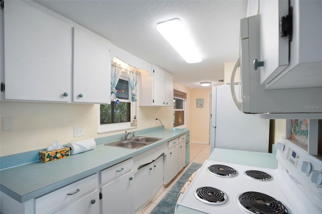 kitchen with white appliances, light tile patterned floors, a textured ceiling, white cabinets, and sink