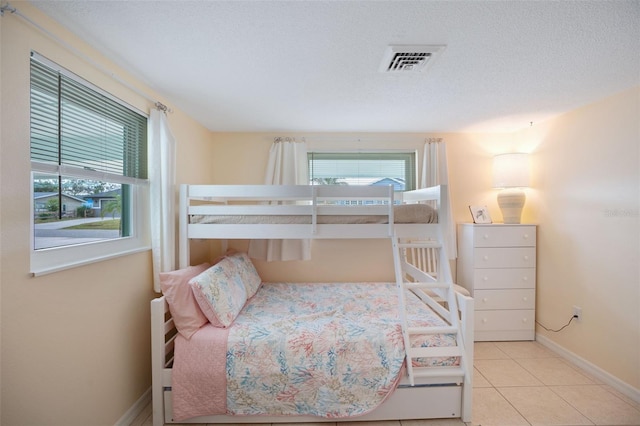 bedroom with a textured ceiling and light tile patterned floors