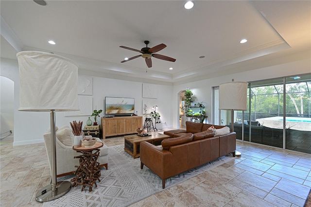 living room featuring ceiling fan and a raised ceiling