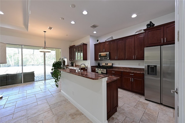 kitchen with dark stone counters, dark brown cabinetry, stainless steel appliances, sink, and pendant lighting