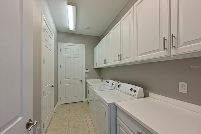 laundry area featuring washer and dryer, light tile patterned flooring, cabinets, and sink