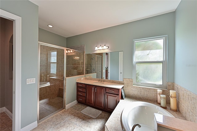 bathroom with tile patterned floors, vanity, and shower with separate bathtub