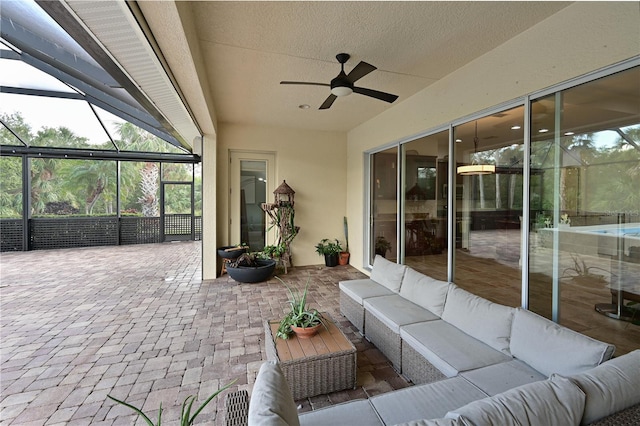 view of patio with outdoor lounge area, ceiling fan, and glass enclosure