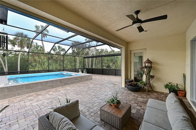 view of patio / terrace featuring an outdoor living space, ceiling fan, and a lanai