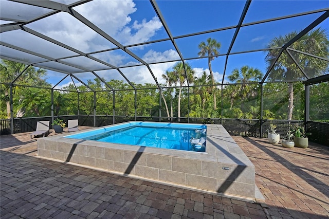 view of swimming pool with glass enclosure and a patio area