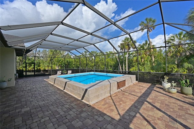 view of pool with glass enclosure and a patio