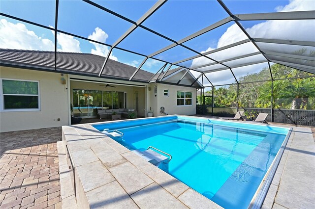 view of swimming pool with ceiling fan, a patio area, a lanai, and an outdoor hangout area