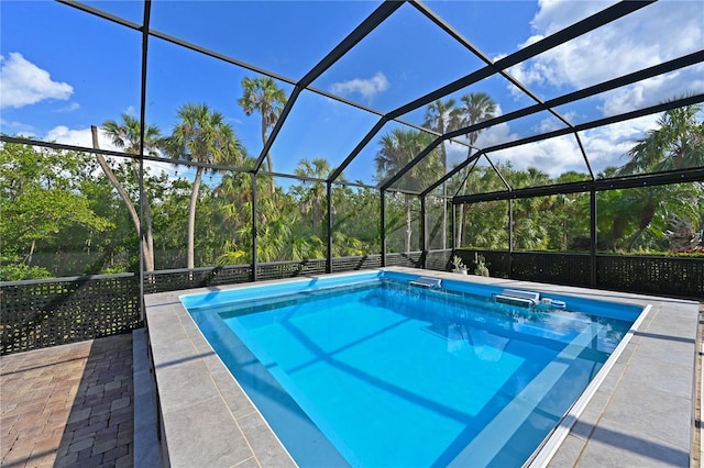 view of pool featuring glass enclosure and a patio