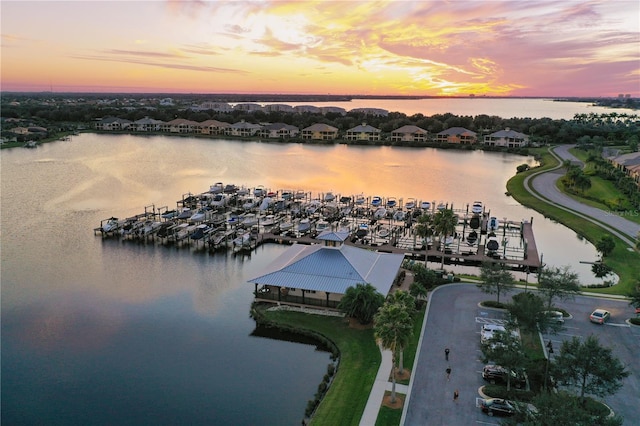 aerial view at dusk featuring a water view