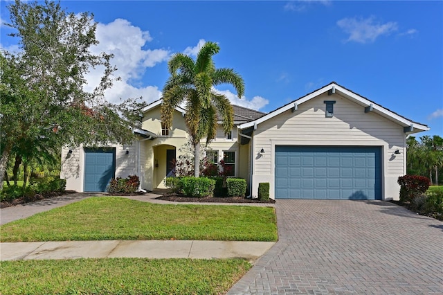 view of front of property with a garage, a front lawn, and decorative driveway