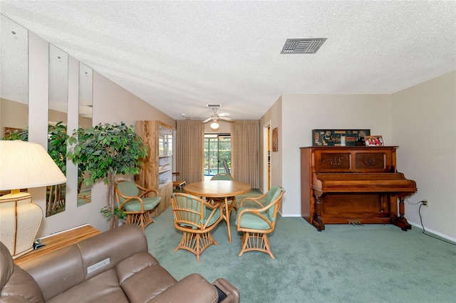 carpeted dining room featuring ceiling fan and a textured ceiling