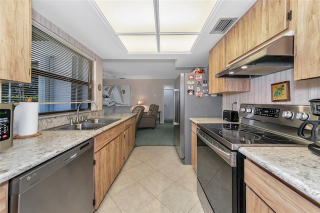 kitchen featuring sink, light tile patterned floors, range hood, and appliances with stainless steel finishes