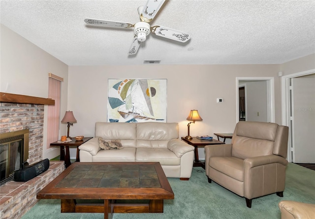 carpeted living room featuring ceiling fan, a fireplace, and a textured ceiling