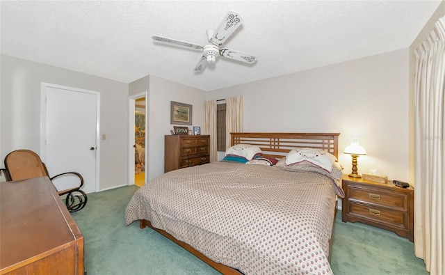 carpeted bedroom featuring ceiling fan and a textured ceiling