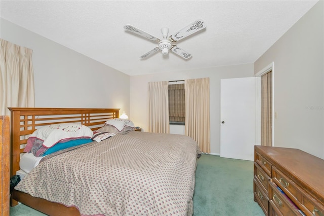 carpeted bedroom featuring ceiling fan and a textured ceiling