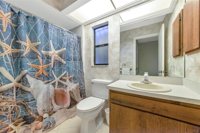 bathroom with toilet, vanity, and tile patterned floors