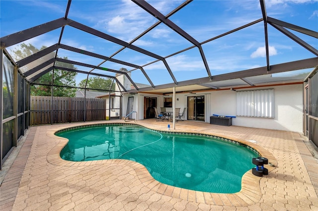 view of swimming pool with ceiling fan, a lanai, and a patio