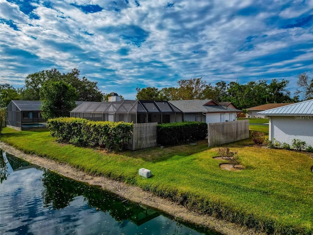 rear view of property featuring a lawn and a water view