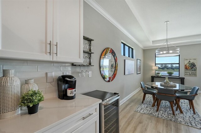 kitchen featuring white cabinetry, light stone countertops, tasteful backsplash, pendant lighting, and light hardwood / wood-style floors