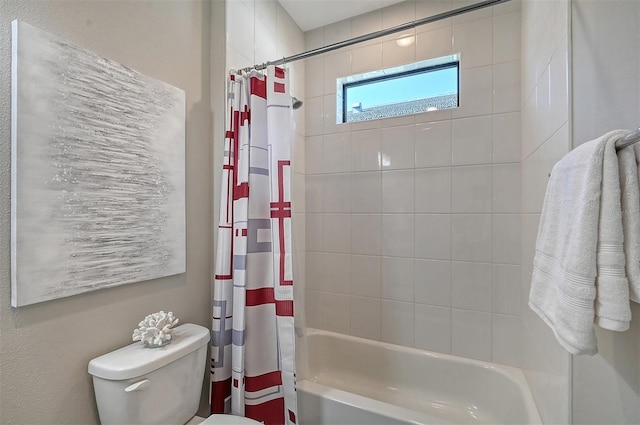 bathroom featuring shower / tub combo and toilet