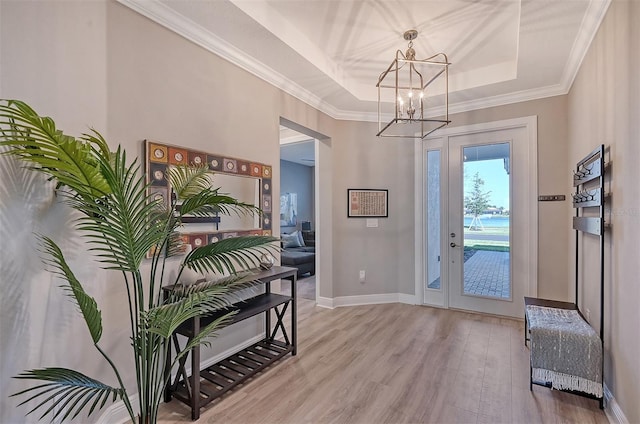 entryway featuring a raised ceiling, light hardwood / wood-style flooring, and a chandelier