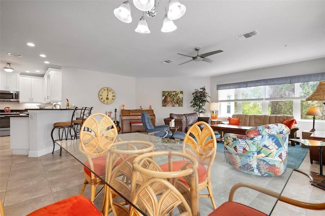 dining space with ceiling fan with notable chandelier and light tile patterned flooring