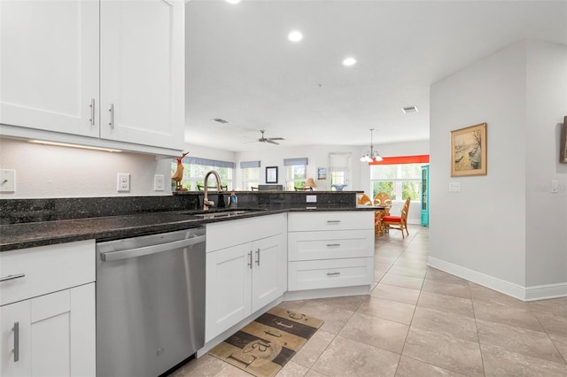 kitchen with stainless steel dishwasher, ceiling fan with notable chandelier, sink, dark stone countertops, and white cabinets