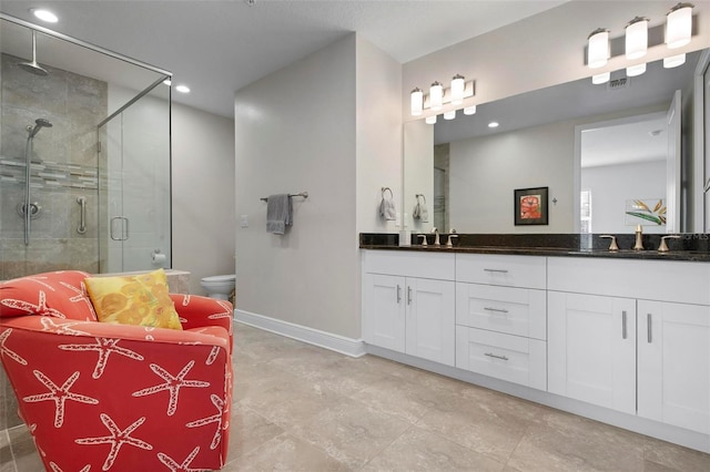 bathroom with vanity, a shower with shower door, and toilet