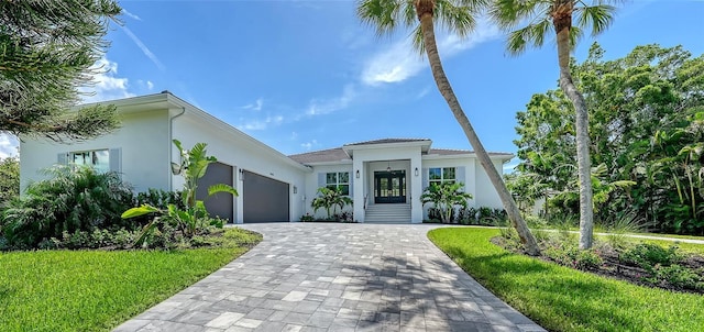 mediterranean / spanish-style home with a garage and a front lawn