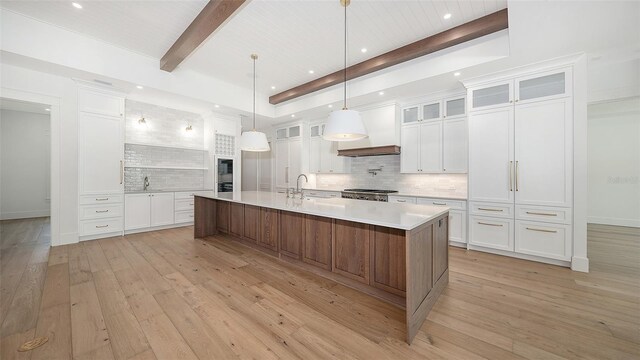 kitchen with decorative light fixtures, white cabinetry, and a large island