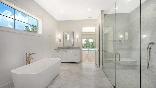 bathroom with separate shower and tub and vanity