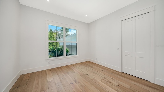 unfurnished bedroom featuring a closet and light wood-type flooring