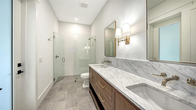 bathroom with tile patterned flooring, vanity, a shower with shower door, and toilet