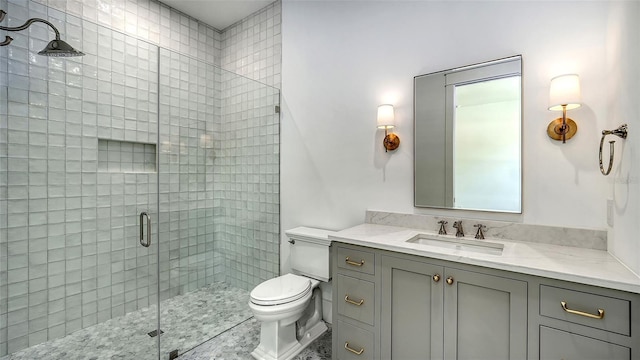 bathroom featuring vanity, toilet, and a shower with door