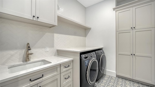 clothes washing area with cabinets, independent washer and dryer, and sink